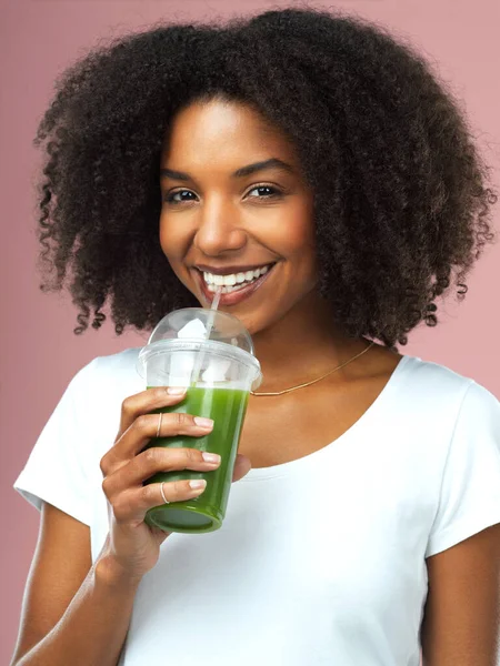 Todas as minhas vitaminas numa bebida. Estúdio tiro de uma jovem atraente bebendo suco verde contra um fundo rosa. — Fotografia de Stock