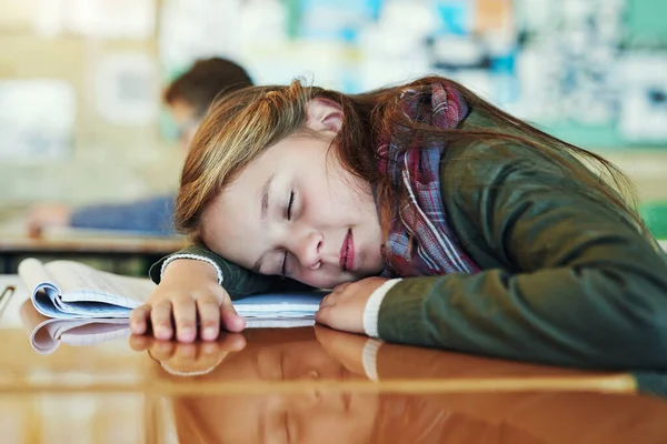 Elle rafraîchit son esprit jeune. Prise de vue d'une adorable écolière du primaire faisant une sieste sur son bureau en classe. — Photo