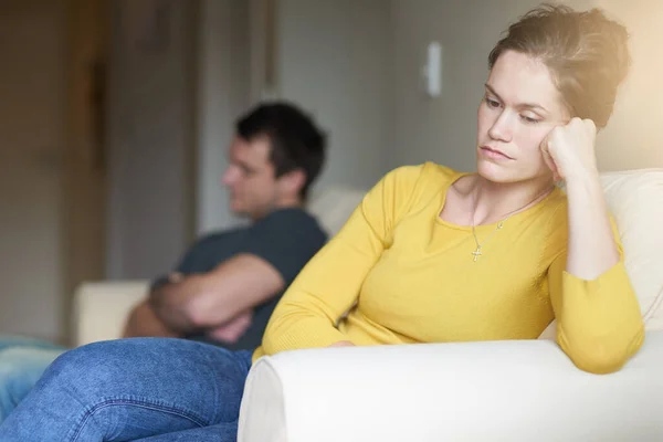 E 'ora del trattamento silenzioso. Ritagliato colpo di un infelice giovane coppia seduta sul divano a casa dopo una lotta. — Foto Stock