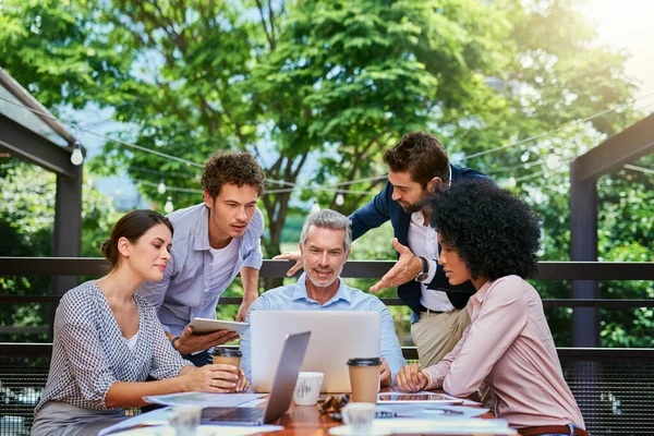 Der Beweis, dass Produktivität überall stattfinden kann. Aufnahme einer Gruppe von Kollegen bei einem Treffen in einem Café. — Stockfoto