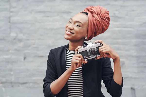 La fotografia è il mio hobby preferito. Ritratto ritagliato di una giovane donna d'affari attraente in posa con la fotocamera contro un muro di mattoni grigi all'esterno. — Foto Stock