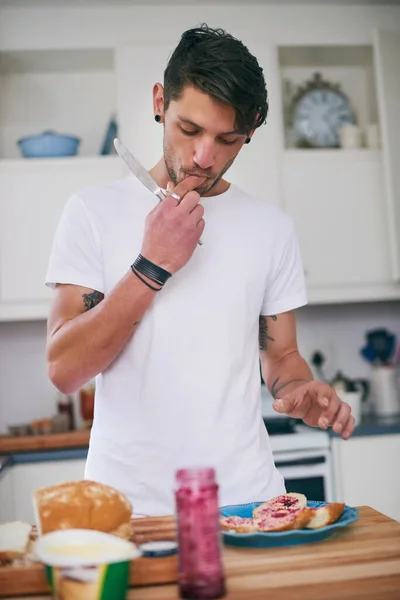 Preparando um lanche saboroso. Tiro de um jovem bonito de pé em sua cozinha fazendo uma sanduíche. — Fotografia de Stock