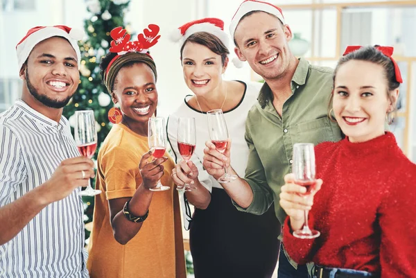 Mindenkinek boldog és boldog karácsonyt kívánunk. Egy csoport kreatív üzletember portréja, akik pezsgőt isznak és együtt ünnepelnek az irodai karácsonyi partijukon.. — Stock Fotó