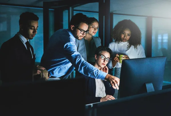 Het duurt langer dan we dachten. Een foto van collega 's die samen aan iets werken op een computer' s nachts.. — Stockfoto