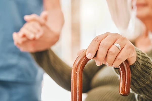 Mijn artritis doet de laatste tijd zeer. Schot van een oudere vrouw met behulp van een wandelstok met de hulp van haar verpleegster. — Stockfoto