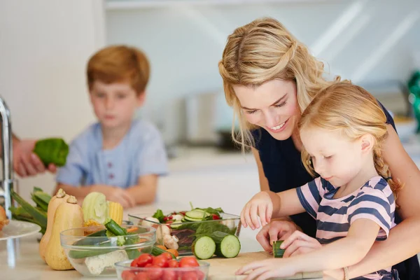 Ze is een geweldige kleine chef. Gehakt shot van een moeder koken samen met haar twee kinderen thuis. — Stockfoto
