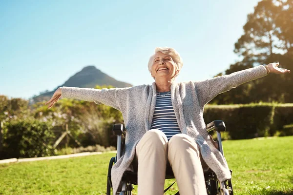 Não lhes tirem a liberdade. Tiro de uma mulher idosa curtindo o ar livre enquanto sentada em sua cadeira de rodas. — Fotografia de Stock