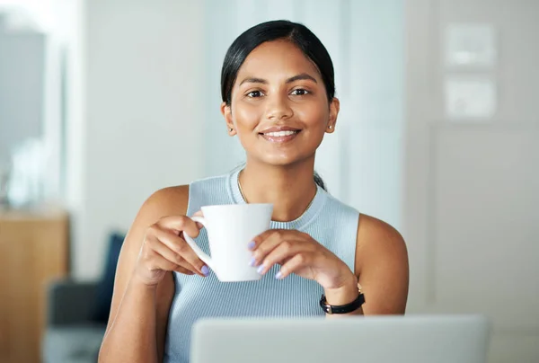Eine Unternehmerarbeit ist nie erledigt. Aufnahme einer attraktiven jungen Frau, die allein an ihrem Küchentisch sitzt und Kaffee trinkt. — Stockfoto