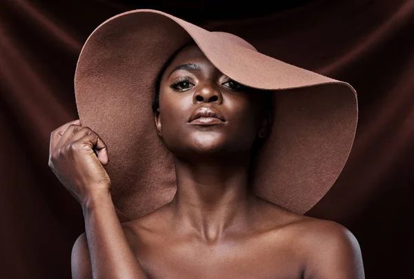 Sigue creciendo y brillando. Fotografía de una hermosa joven con un sombrero posando sobre un fondo marrón. — Foto de Stock