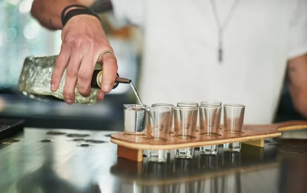 Laten we dit feestje beginnen. Gehakt schot van een onidentificeerbare barman gieten schoten achter de bar. — Stockfoto