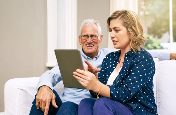 Nunca és demasiado velho para aprender. Tiro de um pai sênior e sua filha adulta usando um tablet juntos em casa. — Fotografia de Stock
