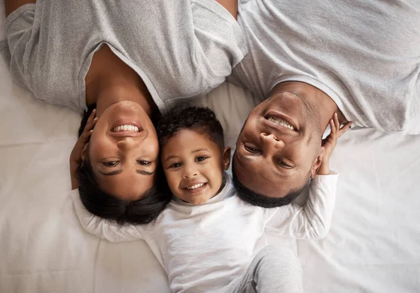 En iyi ebeveynlere sahibim. Genç bir çiftin yatakta yatıp oğullarıyla bağ kurduğu yüksek açılı bir fotoğraf.. — Stok fotoğraf