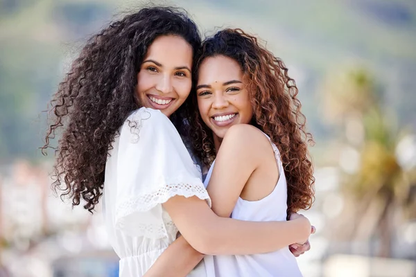 Because of her I smile a whole lot more. Shot of two young women hugging outdoors. — Stock Photo, Image