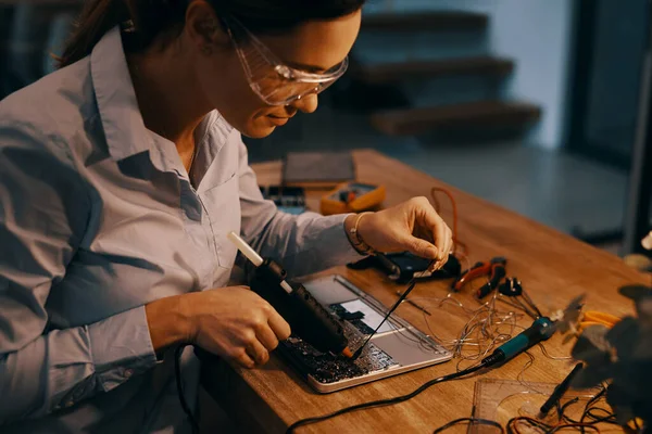 E ora per sigillare tutto. Ritagliato colpo di un attraente giovane tecnico informatico femminile che ripara un computer portatile nel suo laboratorio. — Foto Stock