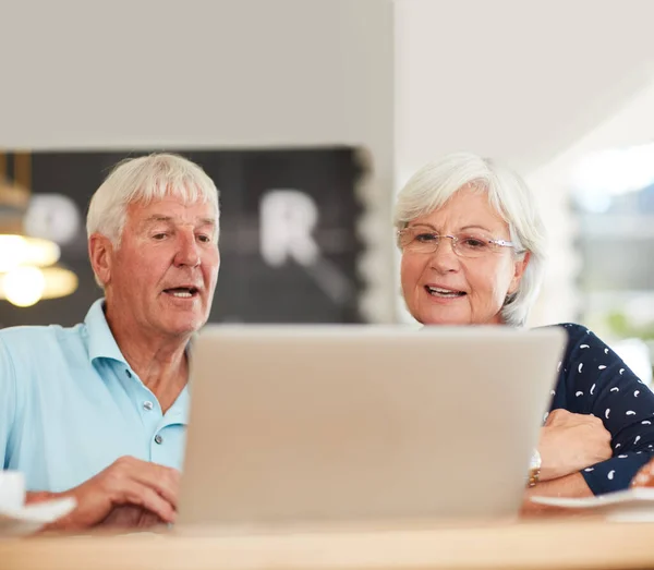 Podemos usar o wi-fi gratuito para fazer praticamente qualquer coisa. Tiro de um casal de idosos usando um laptop juntos. — Fotografia de Stock