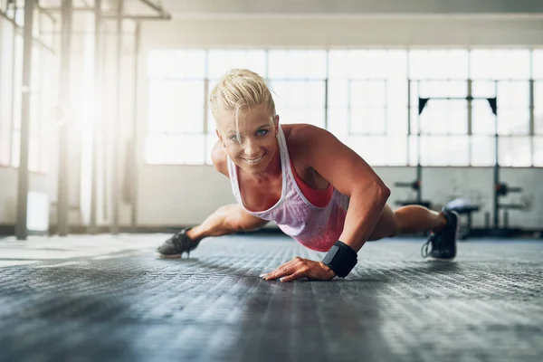 Las excusas no queman calorías. Foto de una joven atractiva haciendo flexiones con una mano en el gimnasio. —  Fotos de Stock