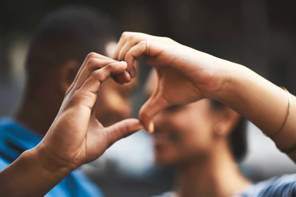 Mitt hjärta kommer alltid att vara ditt. Beskuren bild av ett ungt par som gör en hjärtgest med händerna utomhus. — Stockfoto