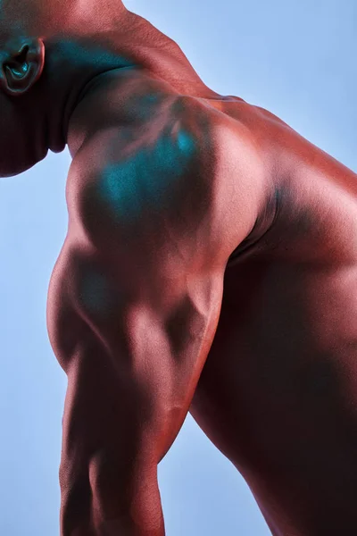 Poner en el trabajo y levantar pesado. Fotografía de un hombre musculoso posando sobre un fondo de estudio. — Foto de Stock