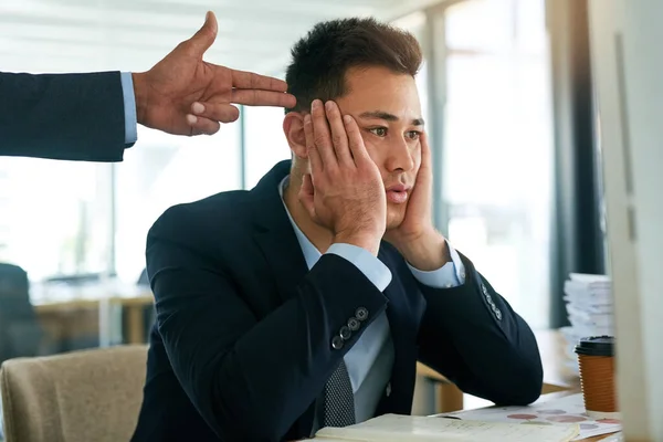 So kann er nicht arbeiten. Schuss eines jungen Geschäftsmannes bei der Arbeit, während ihm sein Chef eine Pistole an den Kopf hält. — Stockfoto