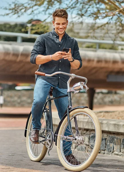 인생은 마치 자전거를 타는 것 과같아서 균형을 유지하면서 계속 움직 이지 않으면 안 됩니다. 한 젊은 남자 학생 이 캠퍼스에서 자전거를 타면서 핸드폰으로 찍은 사진.. — 스톡 사진