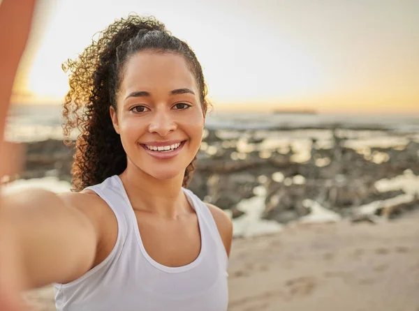 Allenamento completato. Ritratto ritagliato di una giovane donna attraente che si fa un selfie durante il suo allenamento in spiaggia. — Foto Stock