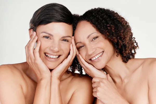 Este regime de cuidados com a pele está a funcionar para nós. Retrato recortado de duas belas mulheres maduras posando contra um fundo cinza em estúdio. — Fotografia de Stock