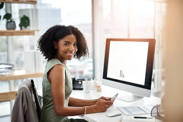 Confianza, una carrera debe tenerla. Fotografía de una joven empresaria usando un teléfono móvil en su escritorio en una oficina moderna. — Foto de Stock