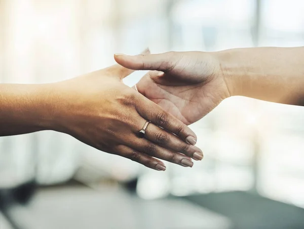 Sacude al acuerdo. Primer plano de dos empresarias irreconocibles dándose la mano mientras están de pie en un lugar de trabajo moderno. —  Fotos de Stock