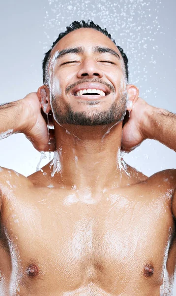 Sinto-me sempre rejuvenescido depois de um duche. Estúdio tiro de um jovem bonito tomando um banho contra um fundo cinza. — Fotografia de Stock