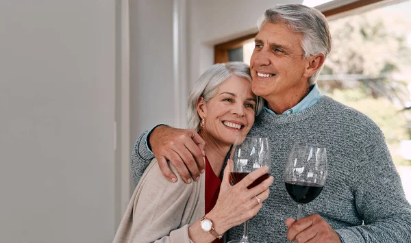 Niets zo romantisch als rode wijn delen. Shot van een gelukkig volwassen paar met rode wijn samen tijdens een ontspannende dag thuis. — Stockfoto