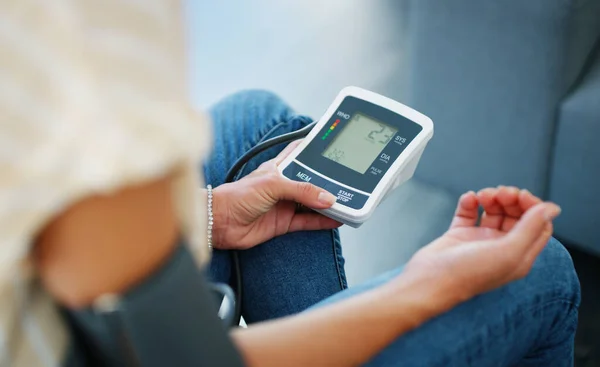 Monitoring my blood-pressure. Cropped shot of a woman checking her blood pressure at home. — Stock Photo, Image