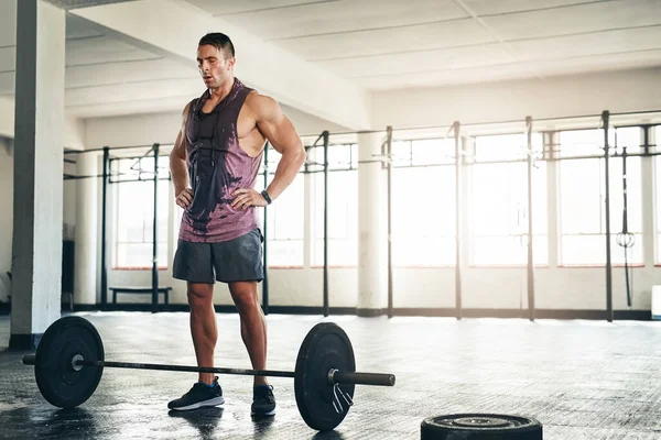 Atravesando la quemadura. Tiro de un joven musculoso levantando pesas en el gimnasio. — Foto de Stock