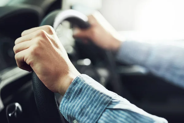 Hands at the ten and two oclock position. Closeup shot of a man driving a car. — Stock Photo, Image