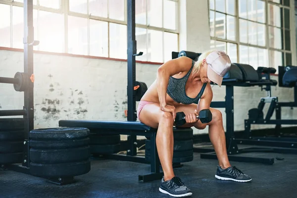 Quemado y firme. Tiro de una joven deportista levantando pesas en el gimnasio. — Foto de Stock