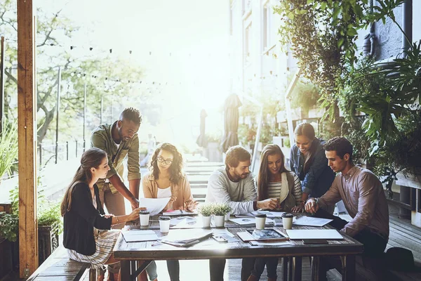 Améliorer la productivité avec un changement de décor. Prise de vue d'un groupe de collègues en réunion dans un café. — Photo