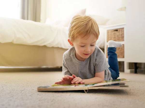 私はゆっくりと今すべての大きな言葉を読むことを学ぶ。家で本を読んでいる少年のショット. — ストック写真