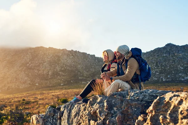 La vista migliore viene dalla salita più difficile. Due escursionisti seduti sulla cima di una montagna a conversare. — Foto Stock