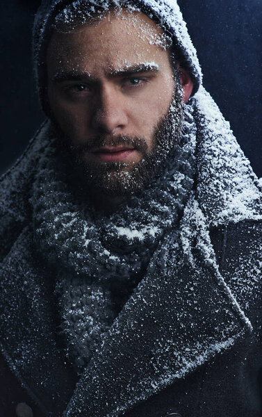 Smouldering snow. Cropped shot of a handsome young man covered in snow.