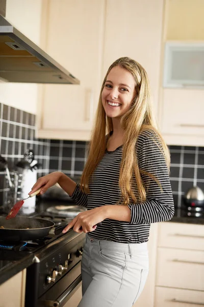 Freír algo fantástico. Foto de una joven feliz preparando una comida en la estufa en casa. — Foto de Stock