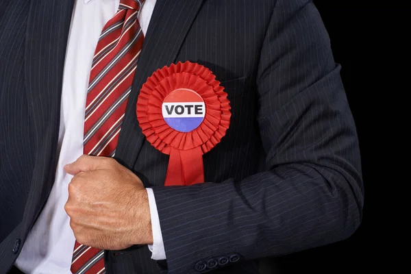 Usen sus votos sabiamente. Vista recortada de un hombre en un traje con una cinta de votación sobre fondo negro. — Foto de Stock