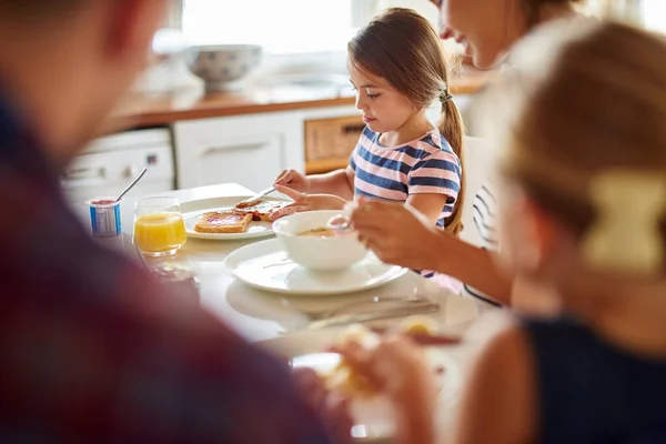 S'amuser à la table du petit déjeuner. Tourné d'une famille prenant le petit déjeuner ensemble. — Photo