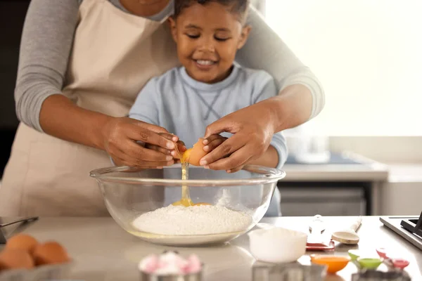 Een les in tederheid. Gehakt schot van een schattige kleine jongen bakken met zijn moeder thuis. — Stockfoto
