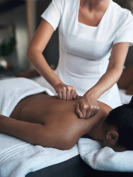 A trabalhar a tensão nesses pontos de pressão. Tiro de uma jovem mulher recebendo uma massagem nas costas em um spa. — Fotografia de Stock