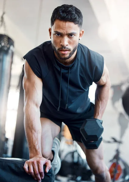No tengo tiempo para debilidad. Retrato de un joven deportivo haciendo ejercicio con una mancuerna en un gimnasio. — Foto de Stock