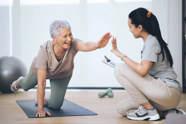 Nicht die durchschnittliche Oma. Aufnahme einer älteren Frau bei leichten Bodenübungen während einer Sitzung mit einem Physiotherapeuten. — Stockfoto