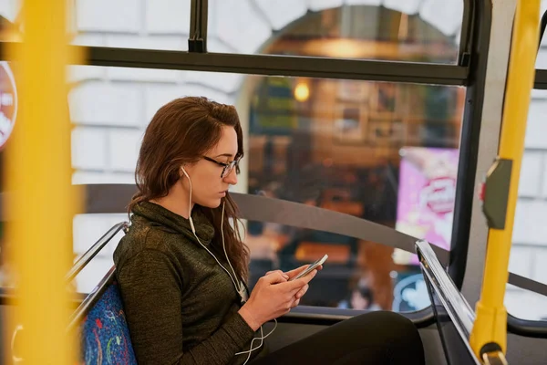 Ela apanha o autocarro por todo o lado. Tiro de ângulo alto de uma jovem atraente ouvindo música enquanto está sentado em um ônibus. — Fotografia de Stock