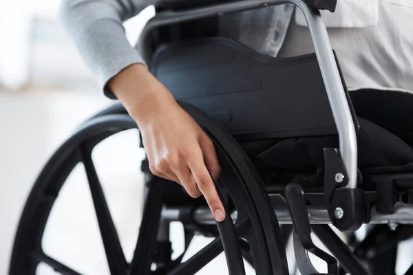 Ela está pronta para se mexer. Foto cortada de uma empresária irreconhecível sentada em uma cadeira de rodas no escritório. — Fotografia de Stock