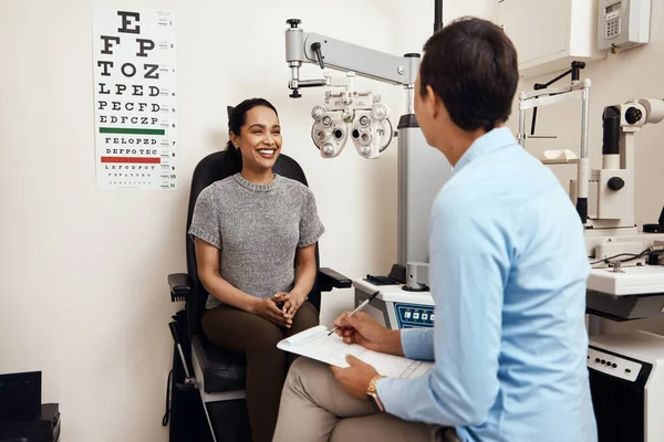Is dit de eerste oogtest die je hebt gehad? Schot van een jonge vrouw met een oogonderzoek door een optometrist. — Stockfoto