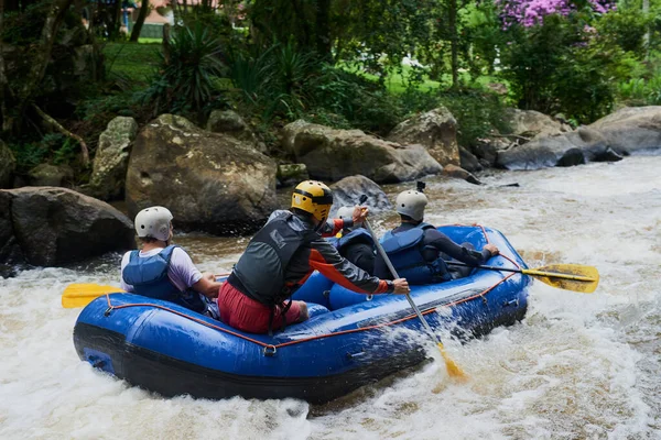 Nature will offer some of the best adventures. Shot of a group of young male friends white water rafting. — Stock Photo, Image