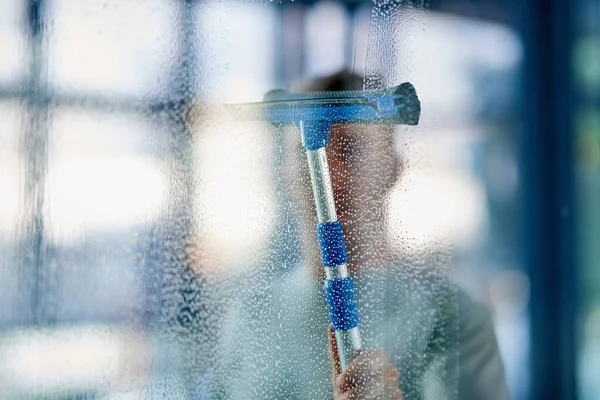 Limpo e higiênico. Tiro de um jovem limpando as janelas do escritório. — Fotografia de Stock